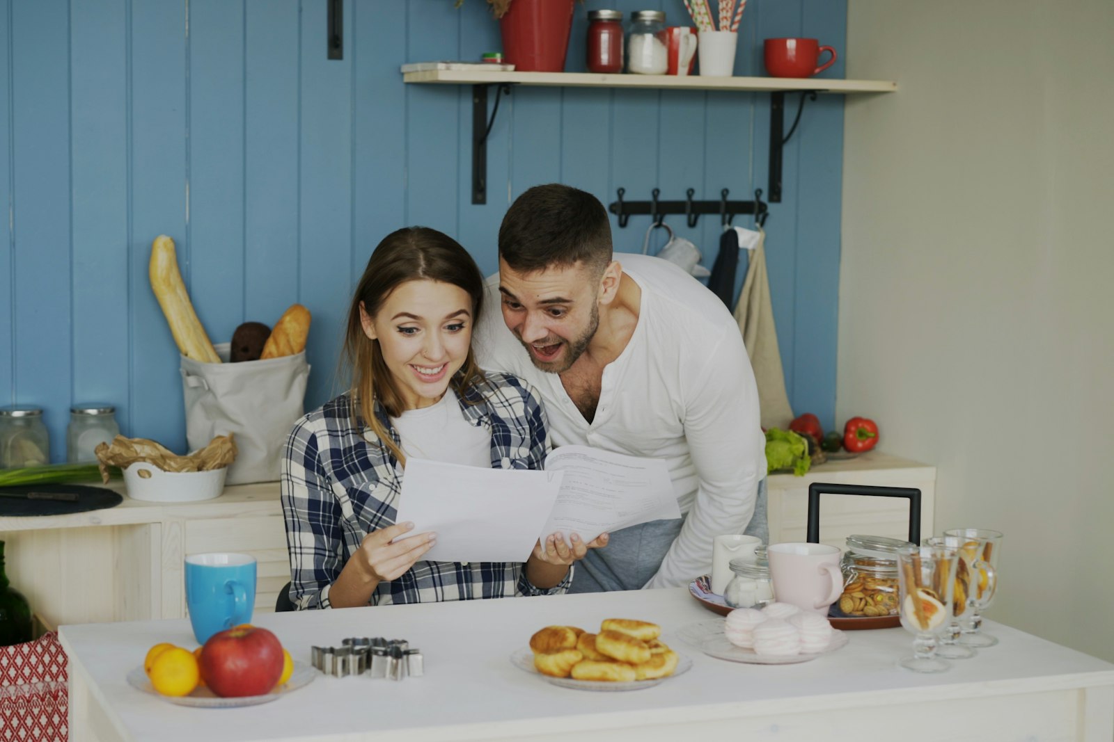 A couple reading through paperwork in a bright kitchen
