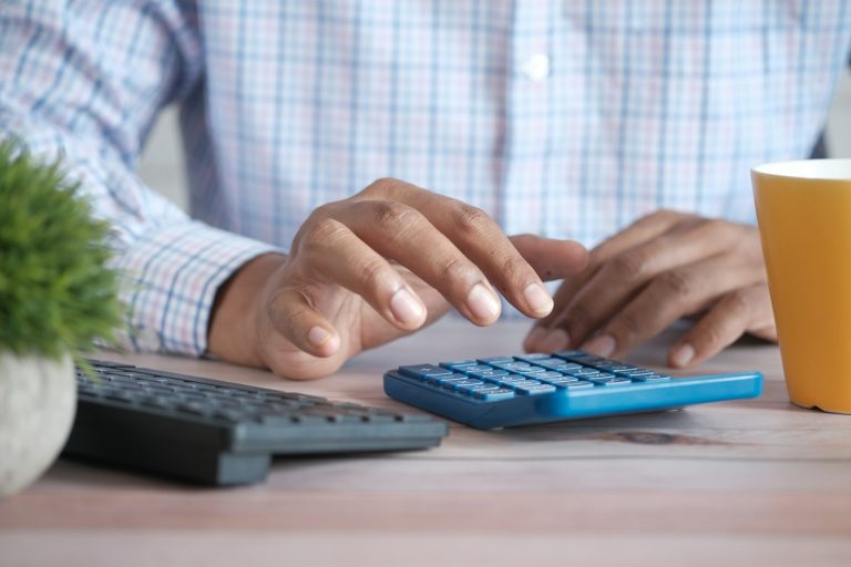 A person working out figures on a calculator at a desk